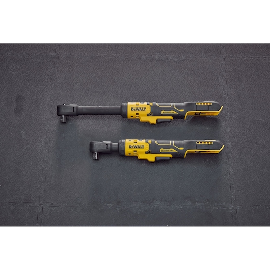 Two DEWALT cordless ratchet wrenches, one with an extended neck and one with a standard neck, are shown side by side on a black textured surface.